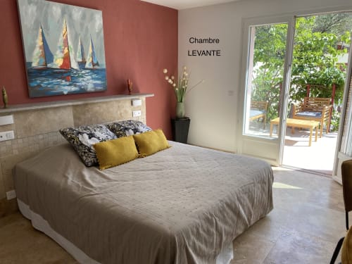 Habitación LEVANTE en Casa Di Floumy en Calvi con obra de velero, acceso a terraza y cojines dorados