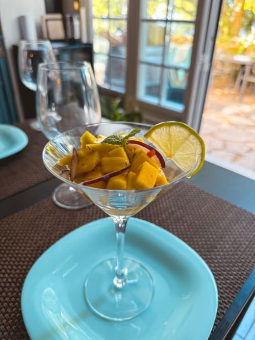 Yellow mango cocktail with lime garnish at Quinta dos Lobos Boutique Hotel in Sintra, Portugal, with garden views through