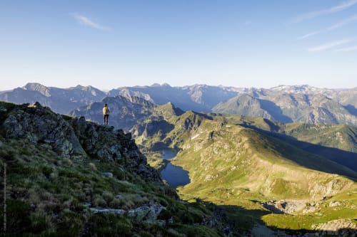 Randonneur avec sac à dos admirant les lacs alpins et les montagnes près d'Ax-les-Thermes