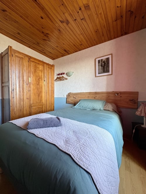 Einfaches Schlafzimmer mit Holzdecke und zwei Einzelbetten im Lo Soulenquo B&B in Golinhac, Frankreich