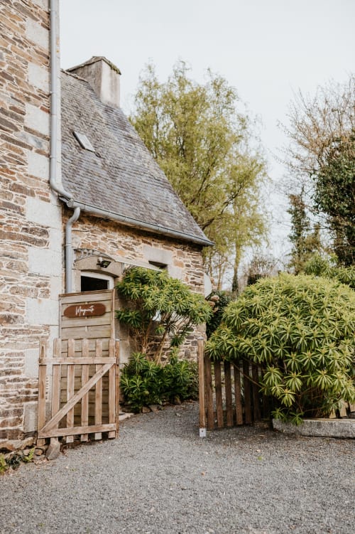 Portail en bois d'entrée du gîte La Grange Marguerite aux Granges De Pil Bara, à Langoat en France, avec bâtiment en pierre