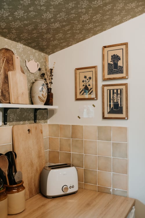 Coin cuisine chaleureux des Granges De Pil Bara avec art botanique encadré, dosseret carrelage beige et bois