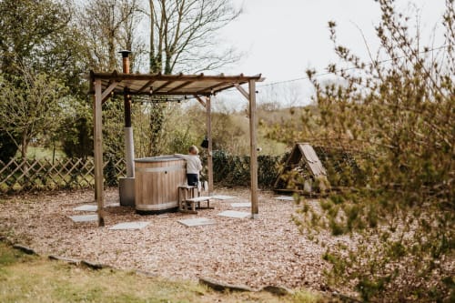 Bain à remous en bois sous pergola au gîte Les Granges De Pil Bara à Langoat, France