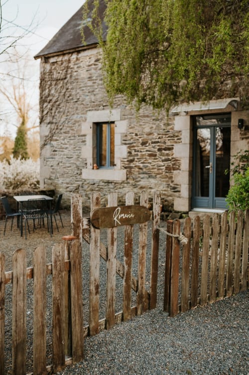 Chaumière en pierre rustique avec lierre, portail en bois « Romarin », cour gravillonnée et coin détente aux Granges De Pil