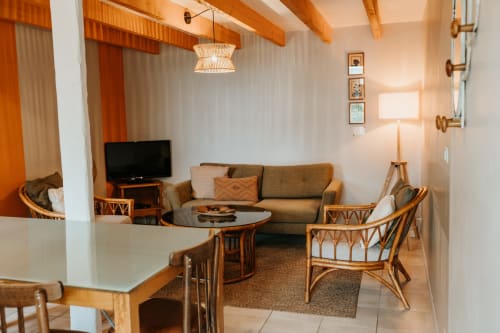 Salon cosy de la grange Romarin aux Granges De Pil Bara, Langoat avec canapé, fauteuils en rotin, TV et boiseries