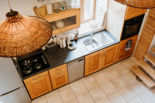 Cuisine moderne au gîte La Grange Romarin aux Granges de Pil Bara avec cuisinière gaz, évier, meubles bois et tissus tressés