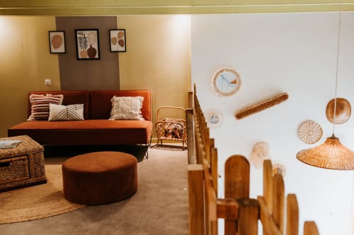 Salon cosy du gîte Les Granges De Pil Bara avec canapé rouille, décoration tissée et meubles en bois naturel à Langoat,