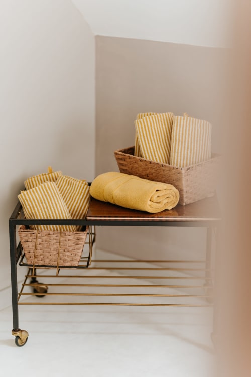 Rangements en lin rustique avec tissus à rayures jaunes et paniers tressés aux Granges De Pil Bara, Langoat