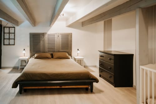 Chambre moderne à la maison d'hôtes Les Granges De Pil Bara à Langoat avec lit queen, commode noire et plafond boisé en pente