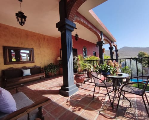 Terraza soleada del Casa Punta Perula Boutique Hotel con arquitectura colorida, zona de estar y vistas a las montañas en Punta