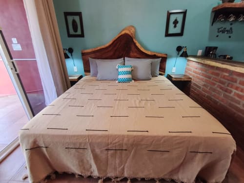 Recámara frente al mar en Casa Punta Perula con paredes turquesas, cama de madera y toques de ladrillo en Punta Perula, México