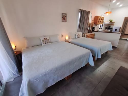 Dos camas en luminosa habitación del Casa Punta Perula Boutique Hotel, Punta Perula México, con cocineta y diseño moderno