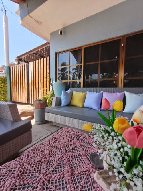 Colorido patio de descanso en Casa Punta Perula con tulipanes, asientos acolchados y postigos de madera en Punta Perula, México