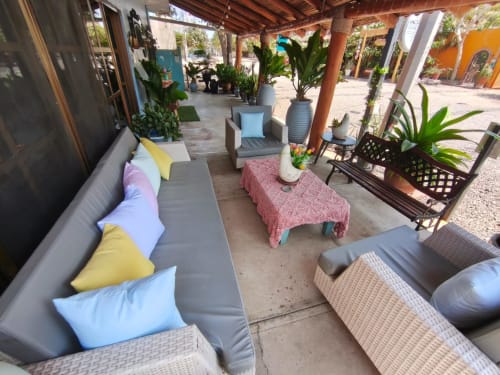 Terraza cubierta de Casa Punta Perula con área de descanso, plantas en macetas y acceso a vista al océano en Jalisco
