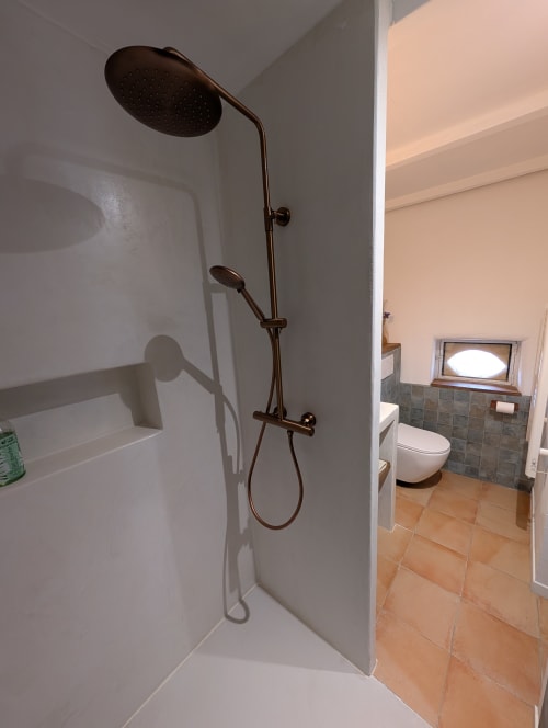 Modern shower stall with rainfall showerhead and handheld spray in Carthagène room at Domaine de Pelican, Gignac