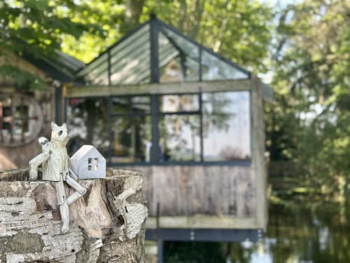 Gîte en verre moderne au Domaine ForRest B&B à Lay, France, avec sculpture de nichoir en bois sur vieille souche