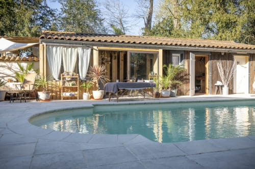 Chalet forestier au Domaine ForRest à Lay, France avec piscine turquoise, terrasse en bois et vue sur le jardin
