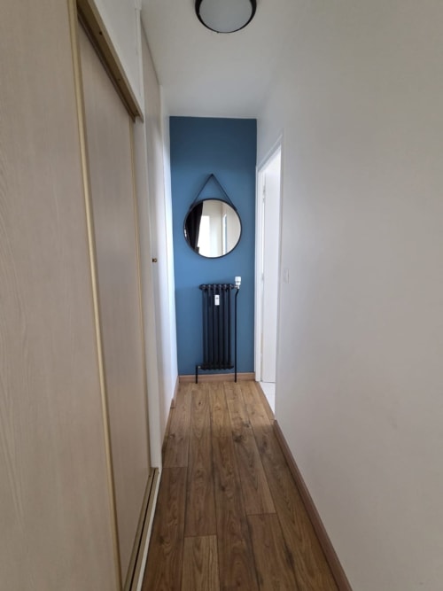 Couloir moderne de l'appartement Le Sympa à l'hôtel NN Patrimoine, Douvaine, avec mur d'accent bleu, miroir rond et