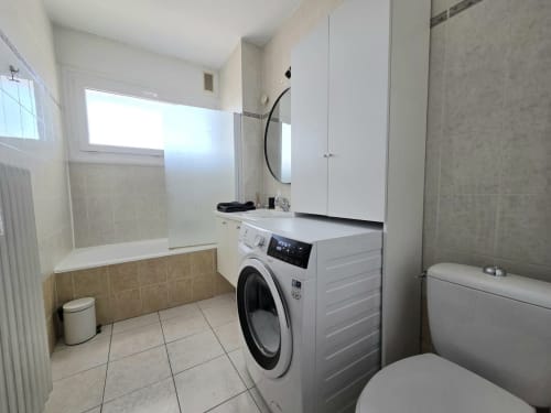 Salle de bains moderne avec lave-linge et vasque de la résidence NN Patrimoine à Douvaine