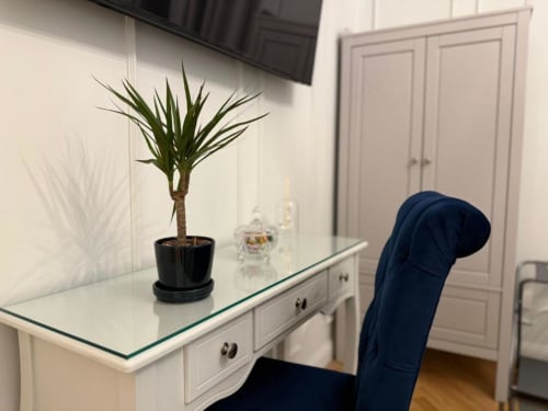 Moderno banco della reception con piccola palma e sedia presso la Residenza Seconnino a Napoli