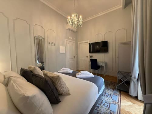 Elegante camera doppia presso la Residenza Seconnino a Napoli con lampadario, TV a schermo piatto e arredi moderni