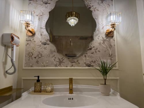 Elegante lavabo del bagno nella suite Residenza Seconnino Napoli con specchio in marmo, rubinetteria dorata e accessori decorativi