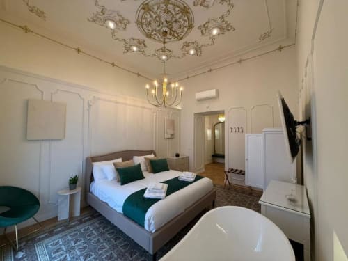Suite elegante presso Residenza Seconnino a Napoli con letto matrimoniale, vasca idromassaggio, soffitto decorato e vista sulla città