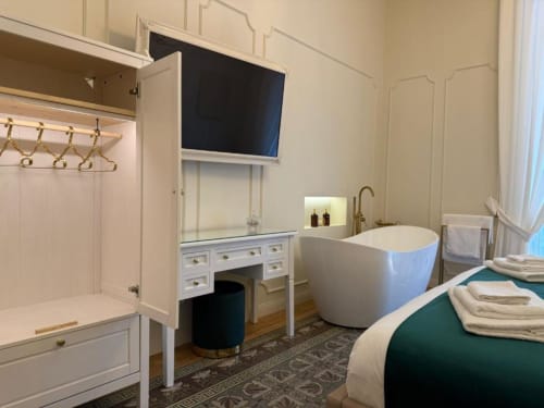 Suite lussuosa della Residenza Secondino Napoli con vasca idromassaggio indipendente, scrivania vanity con TV e bagno moderno