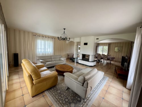 Spacieux séjour du Gîte du Mercadal avec canapé crème, fauteuil jaune, cheminée et vue sur les montagnes à Les Pujols