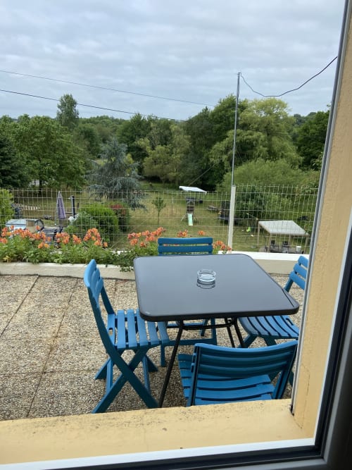 Mobilier de patio bleu surplombant le jardin luxuriant aux Chambres d'hôtes Le Petit Moulin, Pouzauges France