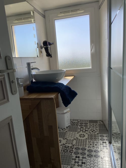 Salle de bain moderne au Le Petit Moulin B&B à Pouzauges avec vasque, carrelage à motifs et vue sur jardin