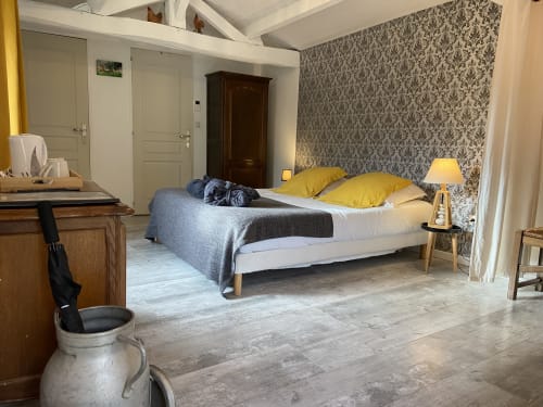 Chambre spacieuse au Petit Moulin B&B à Pouzauges avec lit, papier peint damas et mobilier en bois