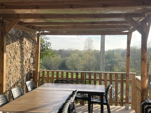 Terrasse couverte avec mobilier en bois surplombant la forêt à la maison d'hôtes Le Petit Moulin, Pouzauges