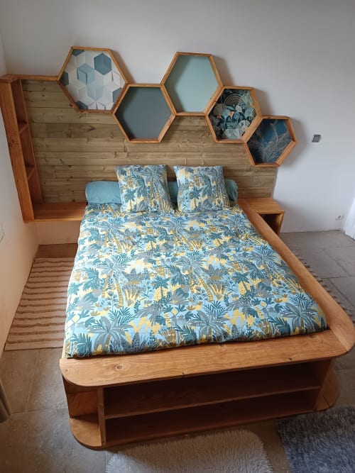 Lit en bois avec parure florale et étagères hexagonales à la Chambre Castellas de La Vigneronne Des