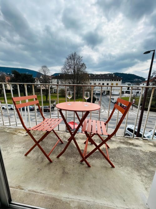 Table et chaises de bistrot rouge sur balcon avec vue sur le lac de Gérardmer et les montagnes, La Conciergerie des Lacs
