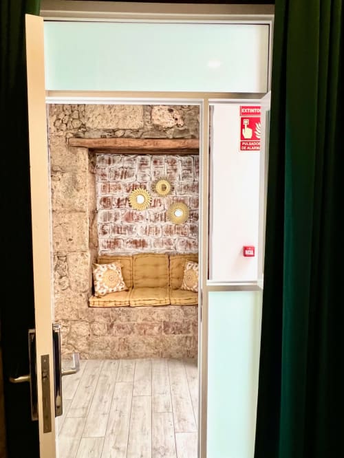 Cozy double room at Hotel The Cathedral Vegueta with exposed brick walls, gold accents, and comfortable seating area