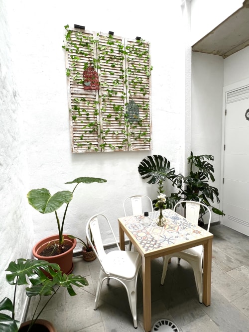 Patio moderno con mesa de comedor, sillas blancas, jardín vertical y plantas en macetas en Hotel The Cathedral Vegueta, Las
