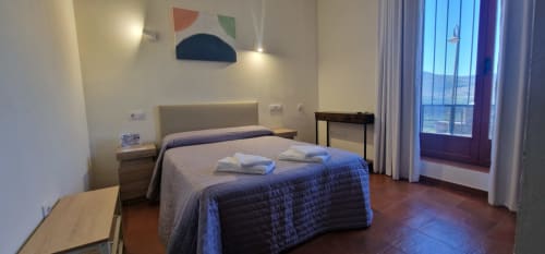 Habitación doble accesible en Hotel Atalaya de Cáceres con vistas al jardín, cama queen, escritorio y comodidades modernas