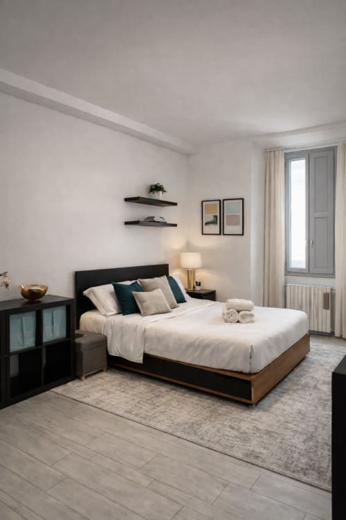 Modern Milano bedroom with queen bed, black nightstands, floating shelves, and neutral décor at HB Hall hotel