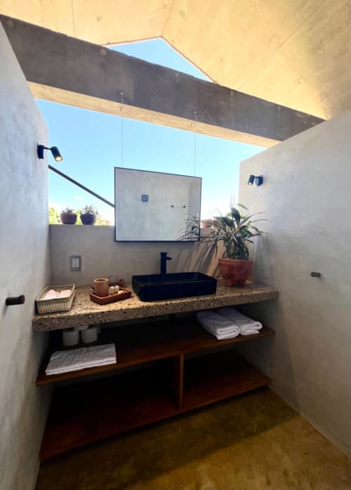 Baño moderno en Casas María Matilda, Puerto Escondido con lavamanos negro, claraboya y estantería abierta.