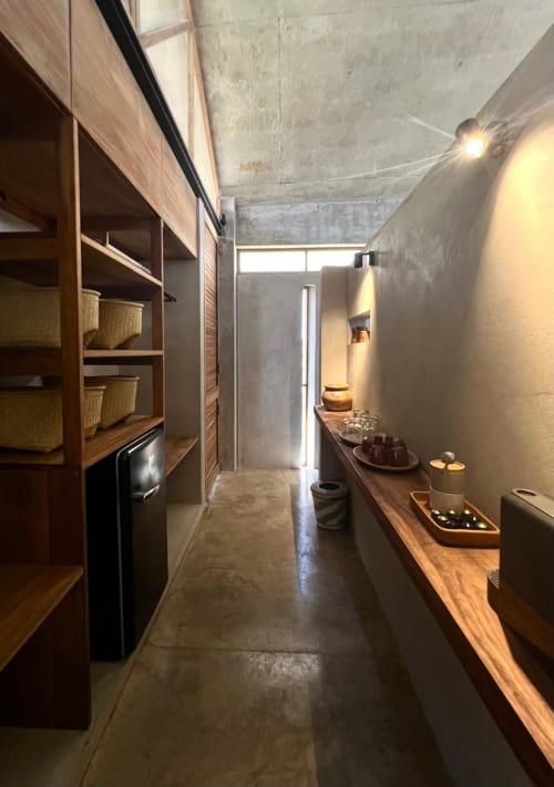 Sala de tratamientos spa de Casas María Matilda en Puerto Escondido con estantes de madera, paredes de concreto y productos de masaje