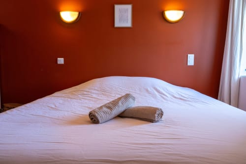 Lou Cerisier room at Eco-hameau Lou Rey in Le Collet de Dèze with twin beds, orange walls, and warm lighting