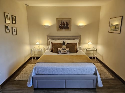 Elegant bedroom at Château de Ribourdin with queen bed, neutral décor, and garden view lighting