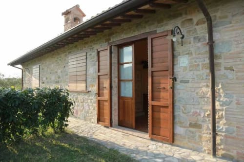 Rustic stone cottage at Agriturismo Colle Mura in Gualdo Tadino with wooden shutters and terracotta roof