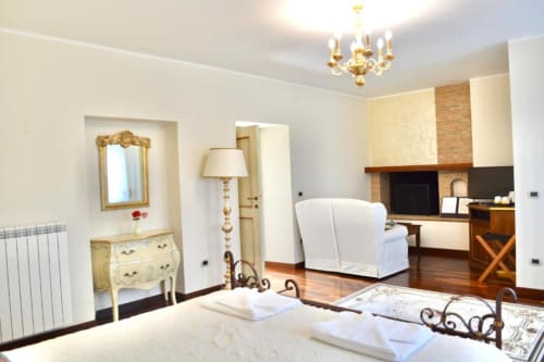 Spacious bedroom at Agriturismo Colle Mura in Gualdo Tadino with fireplace, elegant furnishings and natural light