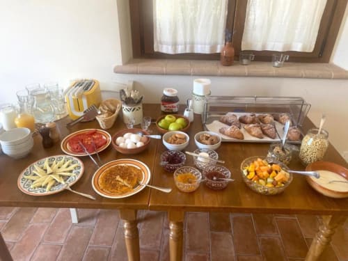 Breakfast spread at Agriturismo Colle Mura in Gualdo Tadino with pastries, fresh fruit, cold cuts, and local Italian products