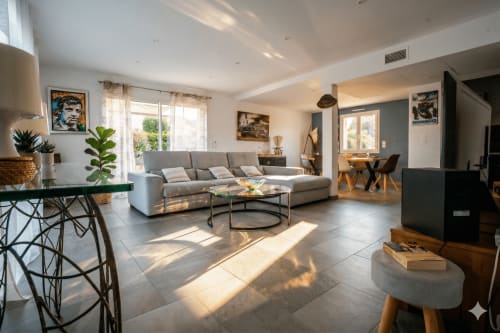 Élégant salon de villa moderne avec canapé gris, table basse ronde et lumière naturelle à Canet-en-Roussillon