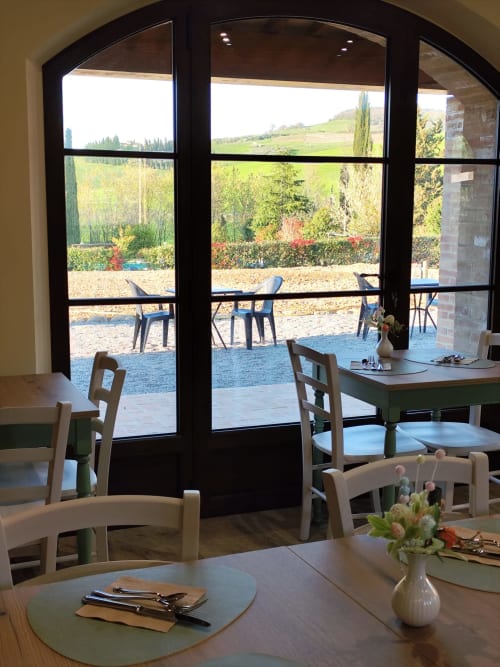 Sala da pranzo dell'Agriturismo Marinello a Pienza con vista sulla campagna e arredamento rustico toscano