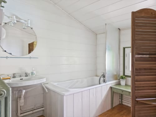 Salle de bain blanche moderne avec baignoire et lavabo sur piédestal à la Villa Rhona à Andancette, France