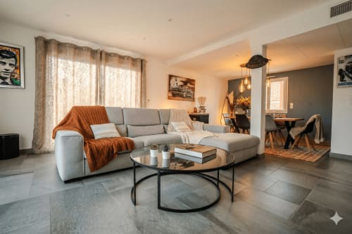 Séjour moderne de la villa Chez Domi à Canet-en-Roussillon, avec canapé gris, table basse ronde et espace ouvert